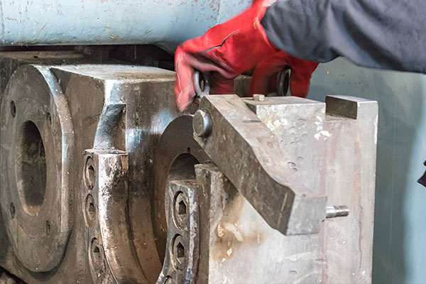 Man working with machinery block | Mann Made, Inc.